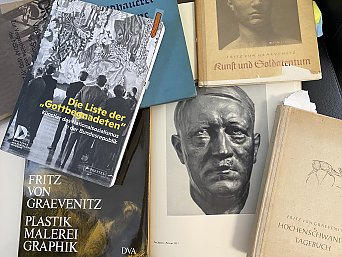 1935 durfte Graevenitz aus nächster Nähe Adolf Hitler porträtieren und es entstand die Bronzebüste. Außerdem fertigte er den riesigen Adler (6m Flügelspannweite) mit Hakenkreuzornat für den Erich-Koch-Platz in ehemals Königsberg, heute Stadion Baltika (Kaliningrad).
Die Fotos zeigen eine Auswahl unserer Recherche-Ergebnisse, die Quellen finden sich entsprechend in den Literaturangaben. 